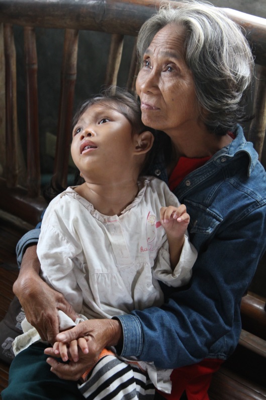 Grandmother looking up as she holds blind child